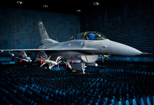 U.S. Air Force photo by Samuel King Jr./Released - https://www.flickr.com/photos/usairforce/15710179866/ A 40th Flight Test Squadron F-16 Fighting Falcon sits in the anechoic chamber after completion of the initial round of testing simulations on the new M-7 software upgrade Oct. 30, 2014, at Eglin Air Force Base, Fla. The M-7 software package will provide multiple advanced capabilities to the aircraft. The anechoic chamber is a room designed to stop reflections of either sound or electromagnetic waves. The room is insulated from exterior sources of noise. The room is part of a facility that allows testing of air-to-air and air-to-surface munitions and electronics systems on full-scale aircraft and land vehicles prior to open-air testing. (U.S. Air Force photo/Samuel King Jr.)